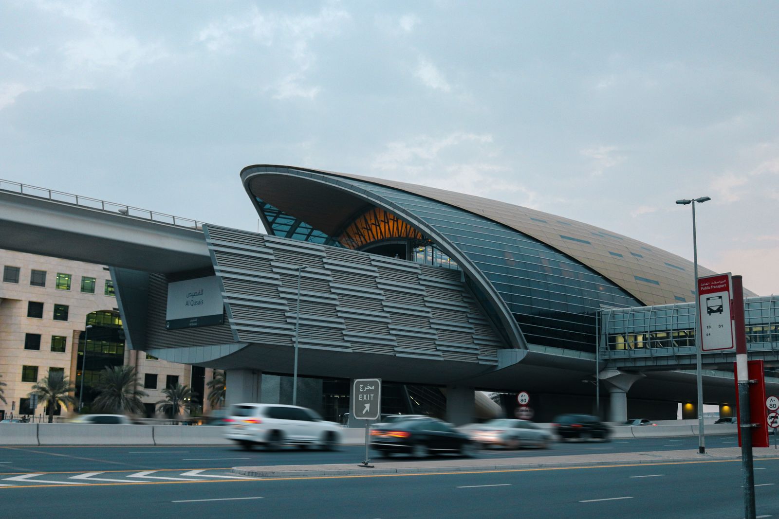 The curved shell roof of a Dubai Metro station seen from the road outside